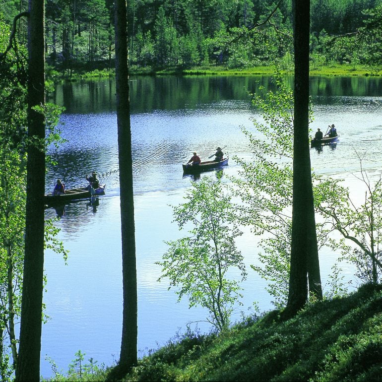 ryhmä meloo tyynellä järvellä, vuokatti kesä