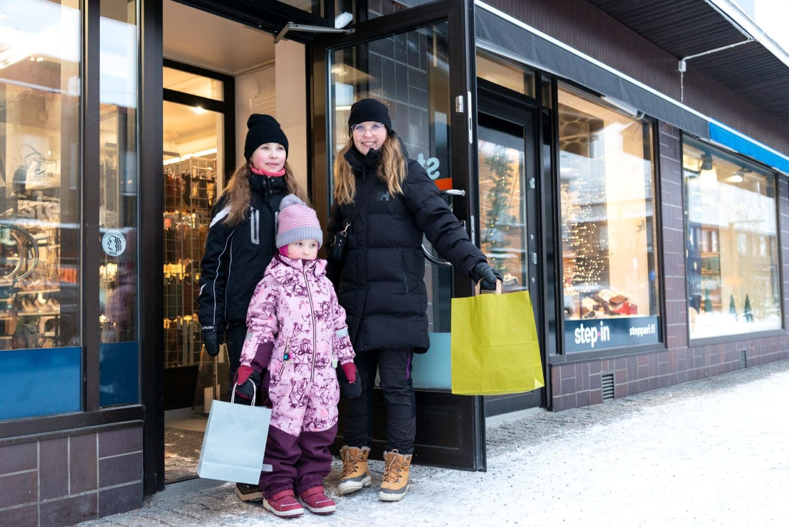 Äiti ja lapset tulevat kaupasta ostosten kanssa