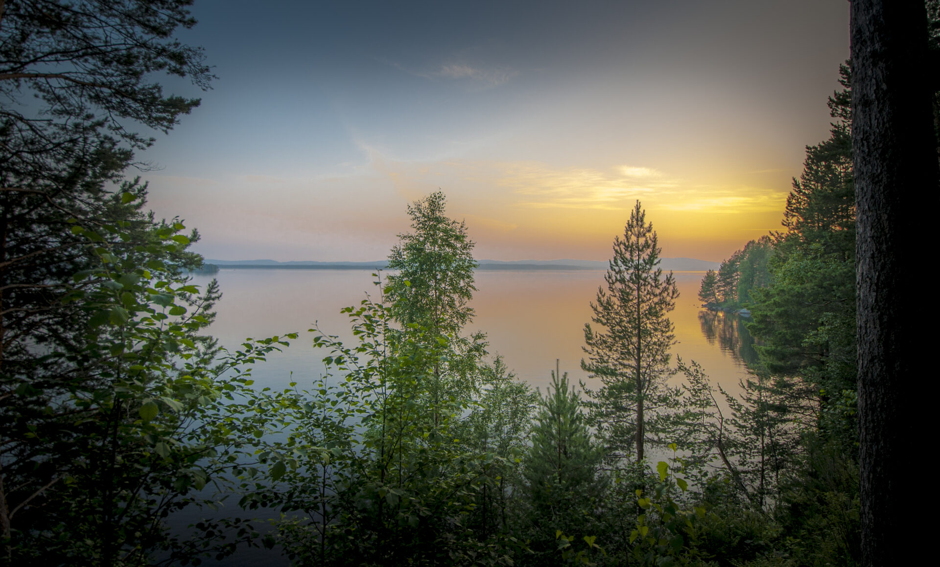 vastuullisuus vuokatti kuva kesäisestä ilta-auringosta järvenrannalla