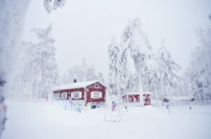 Kuvassa punainen Kahvila Vaaran tupa lumisessa rinnemaisemassa